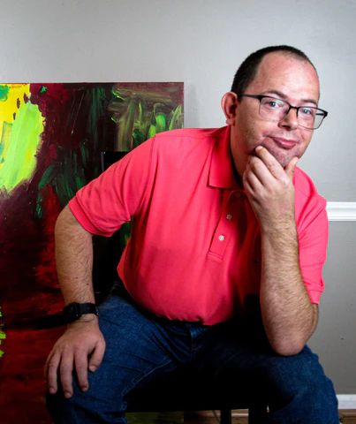 Abstract artist, Wiley Johnson, poses in front of one of his works.